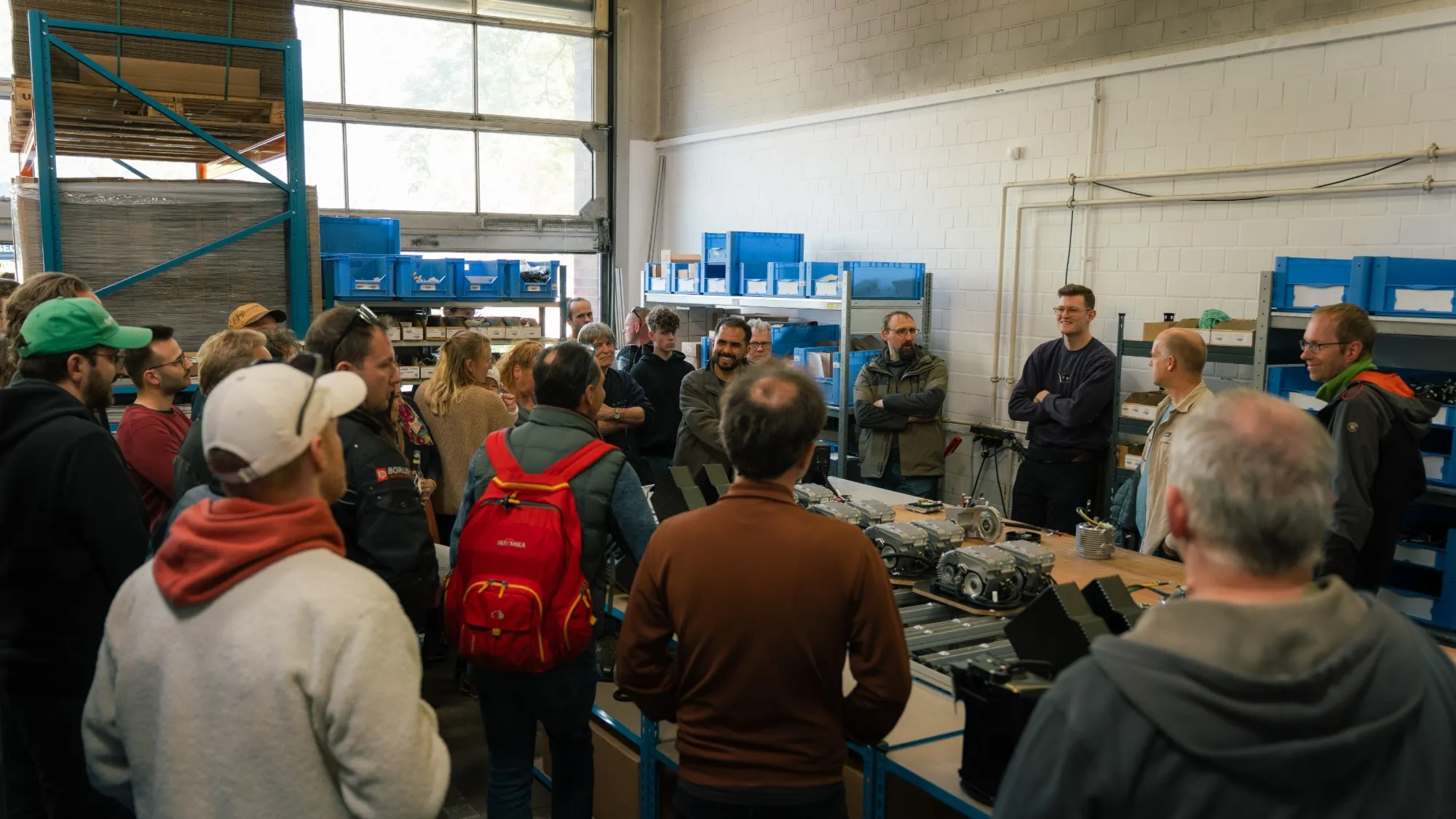 führung durch die produktion von second ride, gäste vor einem tisch mit e-antrieben