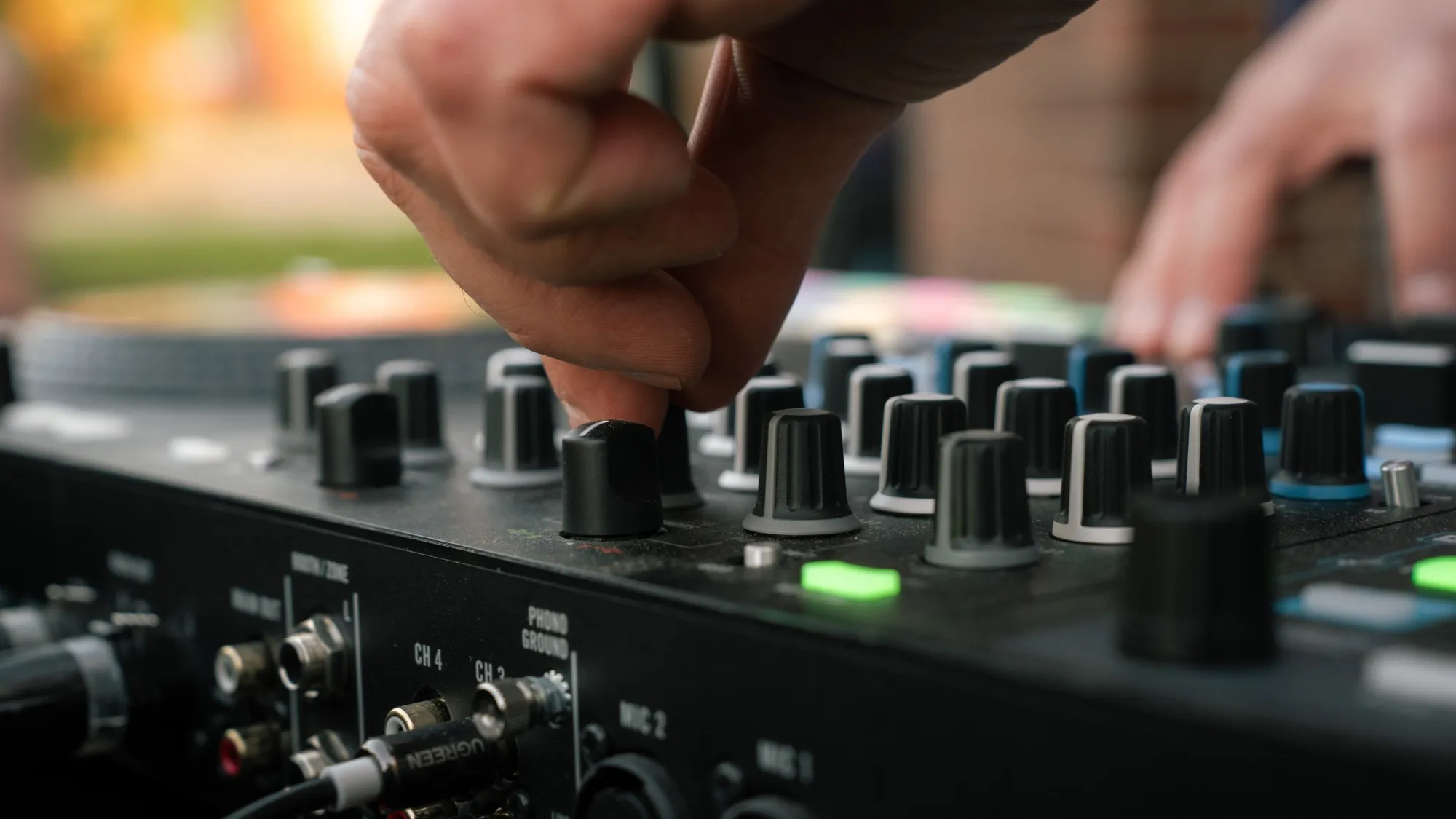 nahaufnahme einer hand am dj-mischpult