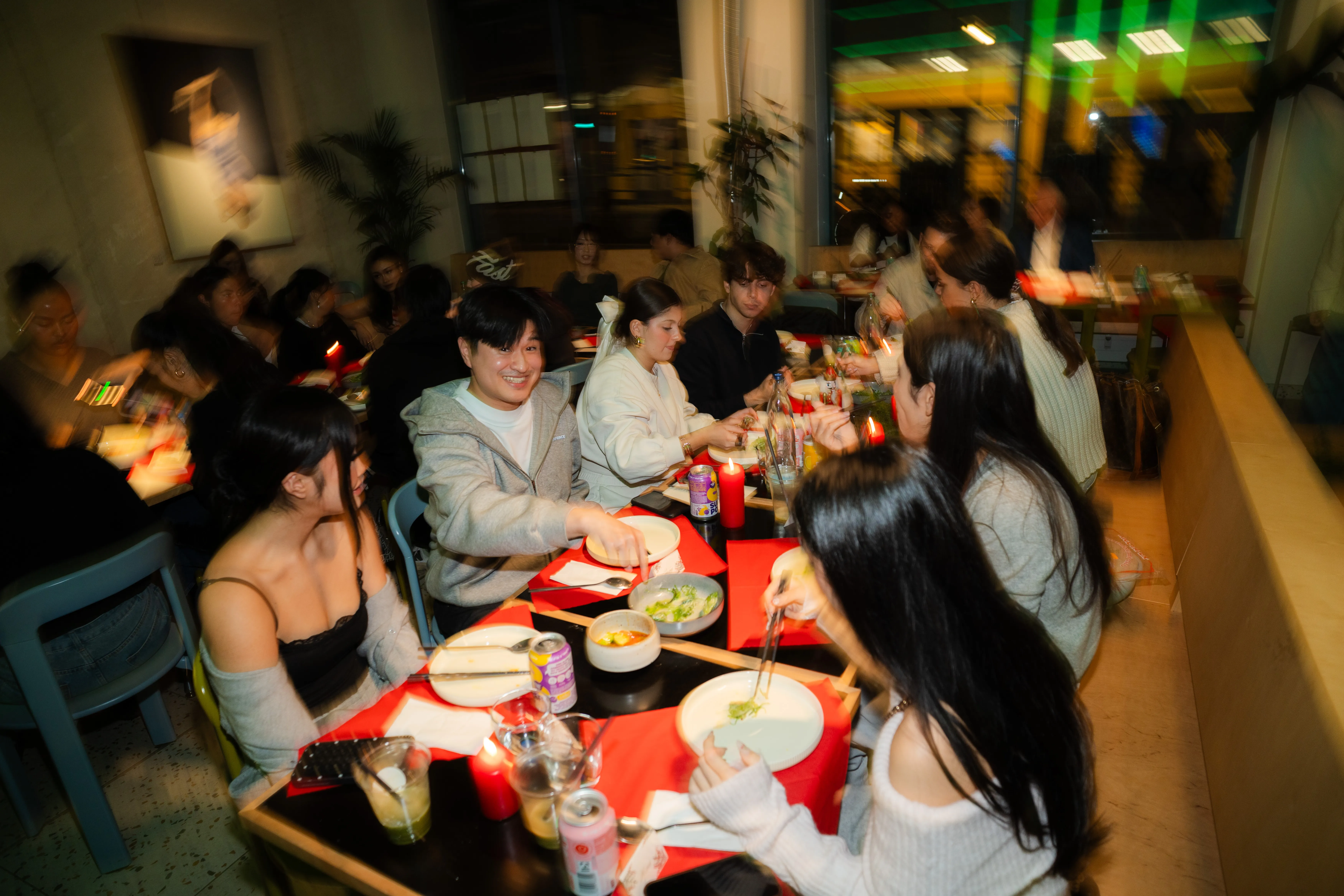 bewegungsunscharfe weitwinkelaufnahme der ganzen gruppe an der langen tischtafel