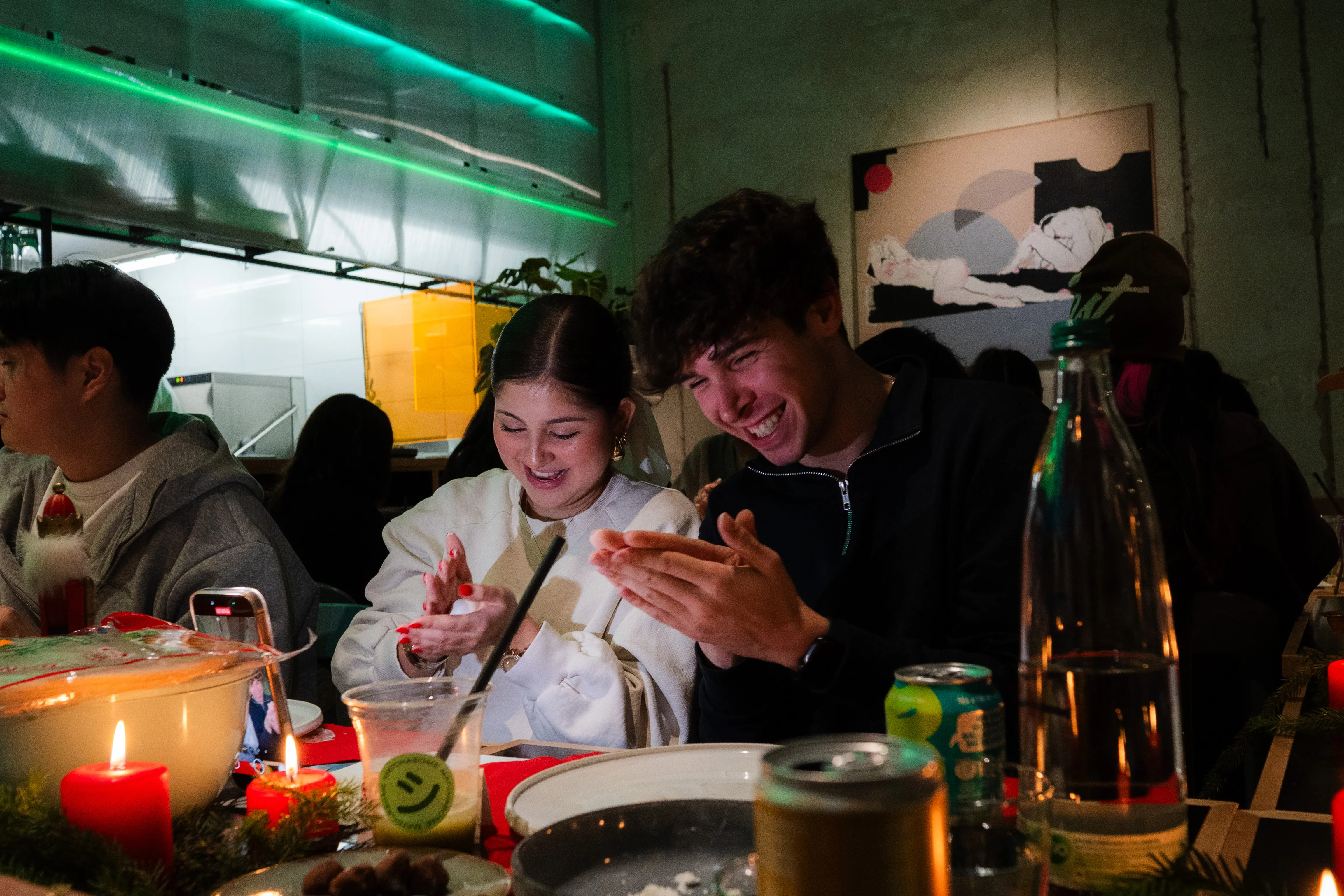 paar lacht und klatscht in die hände beim dumplings-formen, kerzen auf dem tisch