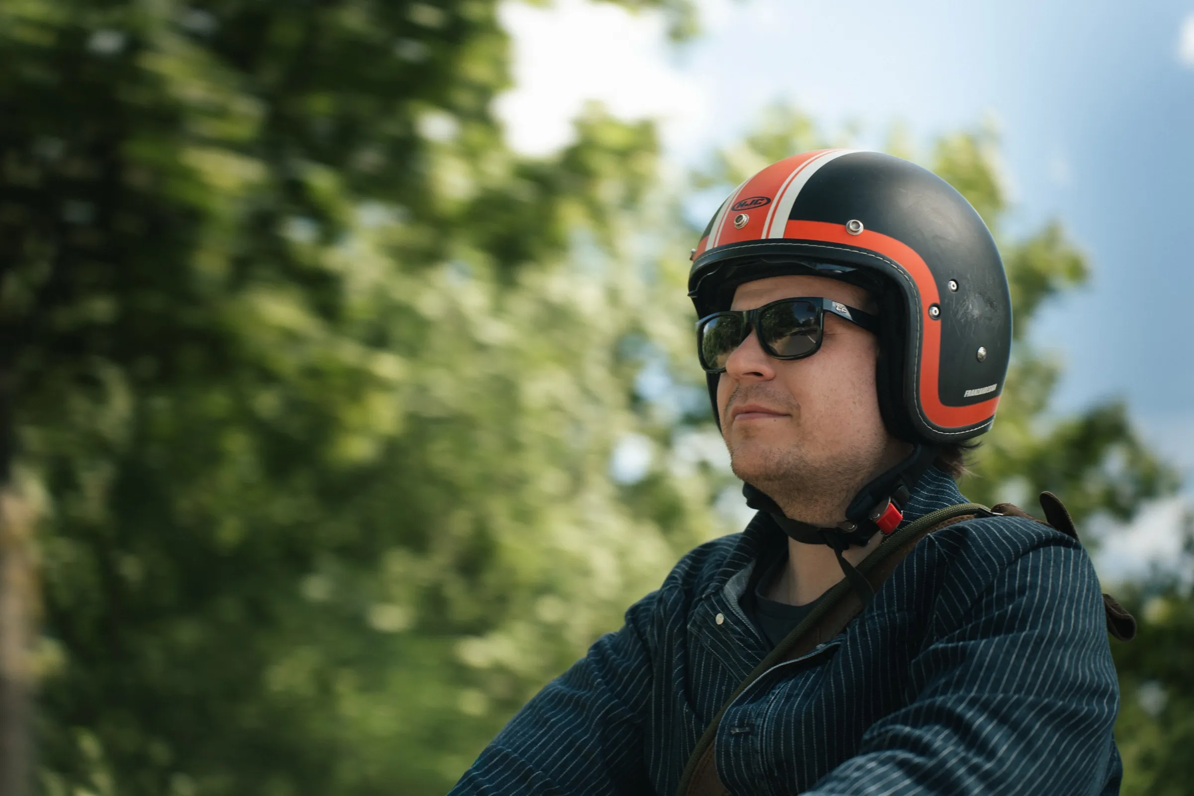 porträt des fahrers mit schwarz-orangem helm und sonnenbrille